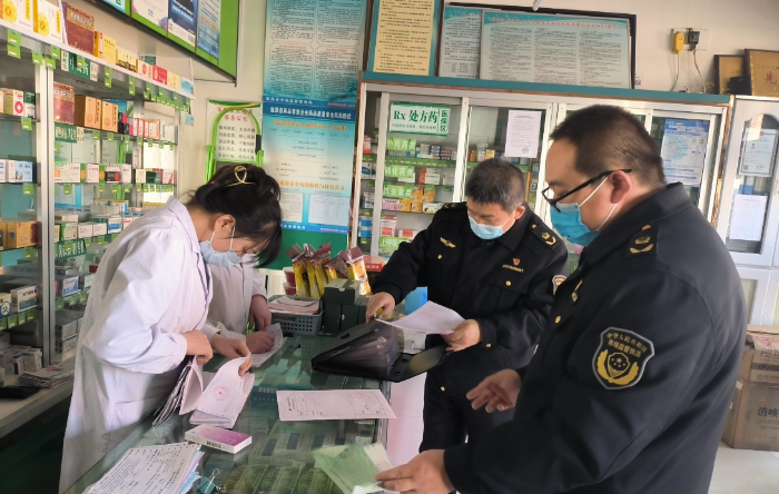 图为该局执法人员在一家药店检查涉疫药品购销记录。