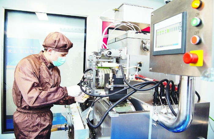 图为在广药国际（澳门）青洲制药厂生产车间，工人正在运用现代化生产设备生产中成药。 广玫 摄