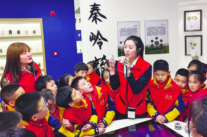 图为陕西省食药检院志愿者为西安高新第一小学的师生们介绍中医药标本。