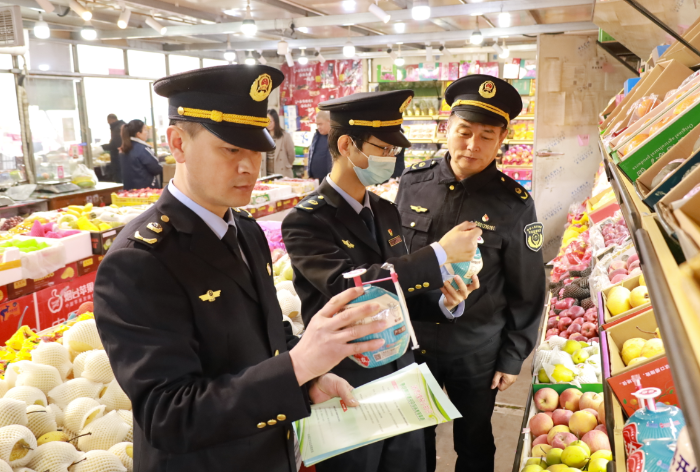 图为武清区市场监管局执法人员在农贸市场检查食品是否在保质期内。