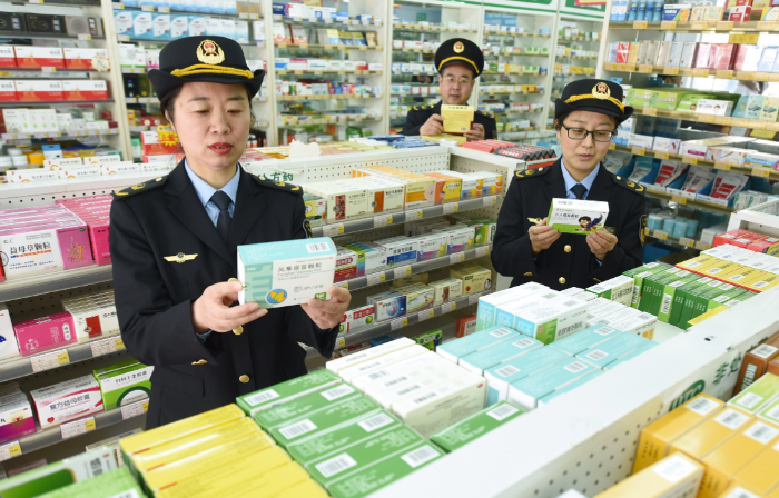 图为东海县市场监管局城东分局执法人员在一家药店检查药品质量。