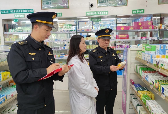 图为执法人员在一家零售药店检查药品质量情况。