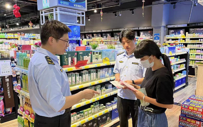 图为该局工作人员在商场向群众宣传化妆品安全知识。