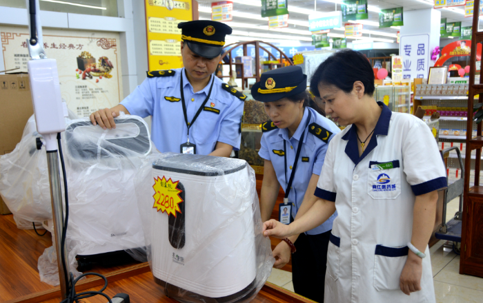 图为7月13日，该局敦仁街道市场监管所执法人员在一家医疗器械经营单位检查制氧机质量。