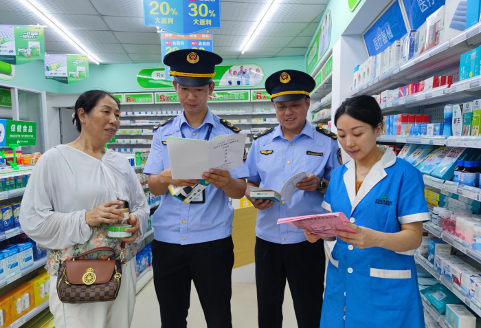 图为7月11日，该局执法人员在一家零售药店向消费者讲解医疗器械安全知识。