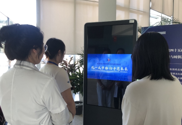 图为北京市药品检验研究院工作人员观看公平竞争政策宣传周公益短片。