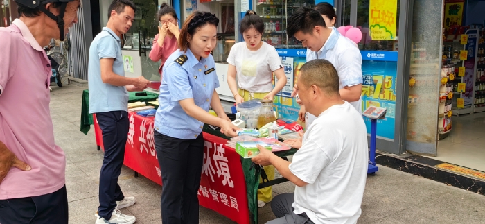 图为滁州市市场监管局工作人员向来往市民发放宣传材料。
