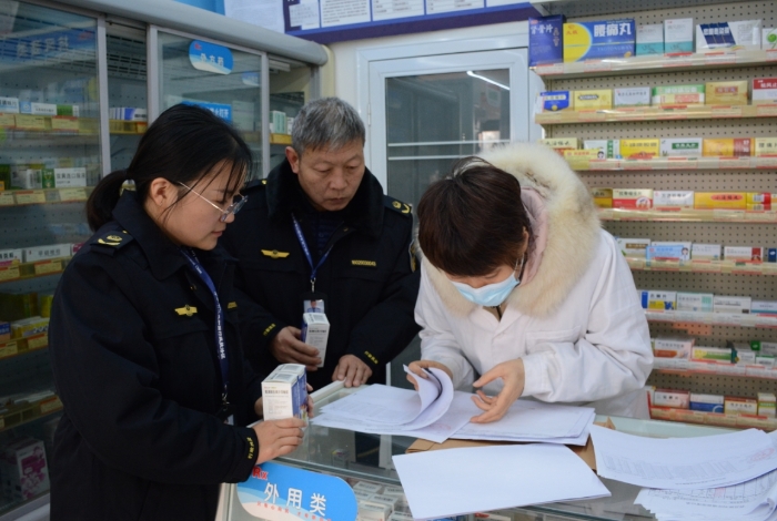 图为执法人员正在一家药品零售企业检查右美沙芬口服单方制剂的销售情况。