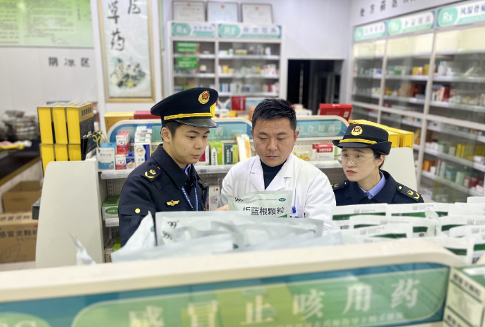 图为该局执法人员在一家药店内检查感冒用药。