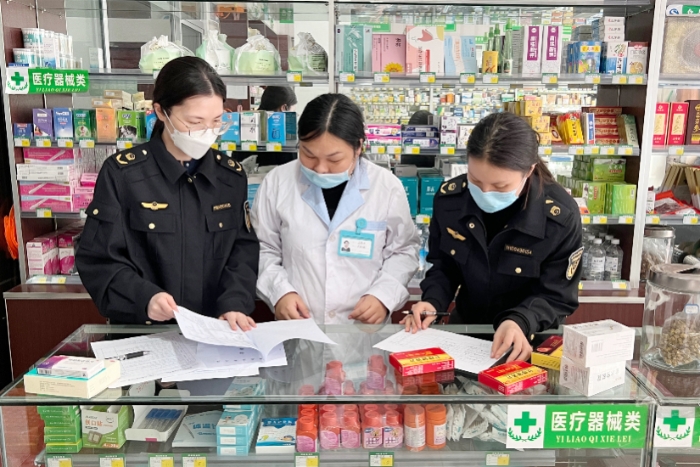 图为该局监管人员在一家药店检查药品、医疗器械进销存数据及票据情况。