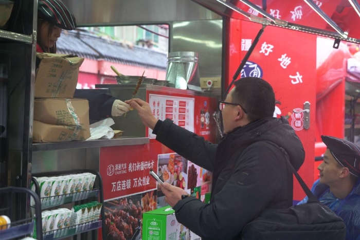 顾客从售货车上购买羊肉串。新华社记者万芃琦 摄