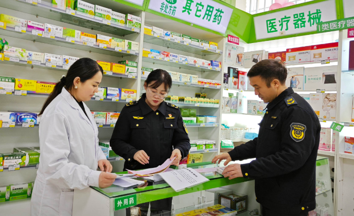 图为该局执法人员在一家药店检查网络药品销售相关备案资料。