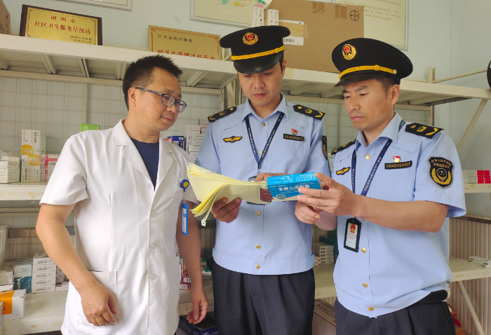 图为该局执法人员在一家药店（社区卫生服务站）进行检查。