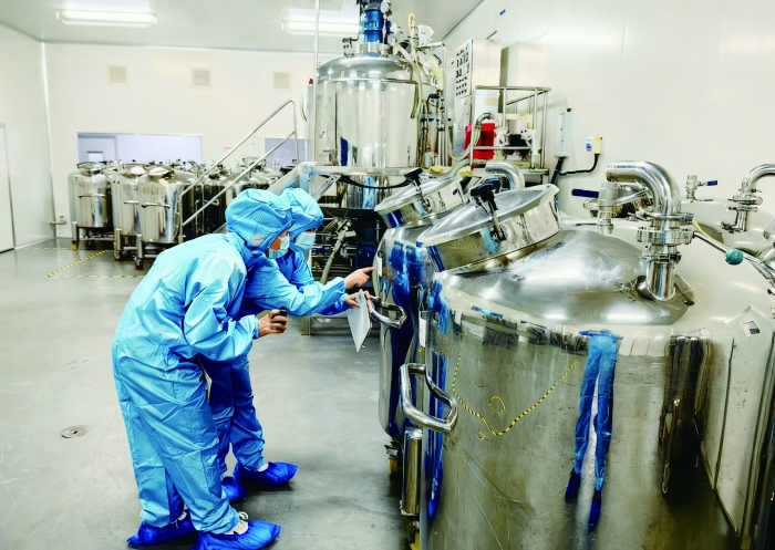 图为在湖南省核查中心开展的一次化妆品生产企业现场检查中，该中心资深检查员正在向新检查员讲解检查要点。 罗雅君 摄