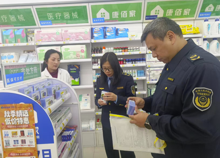 图为该局执法人员在一家药店检查药品质量。