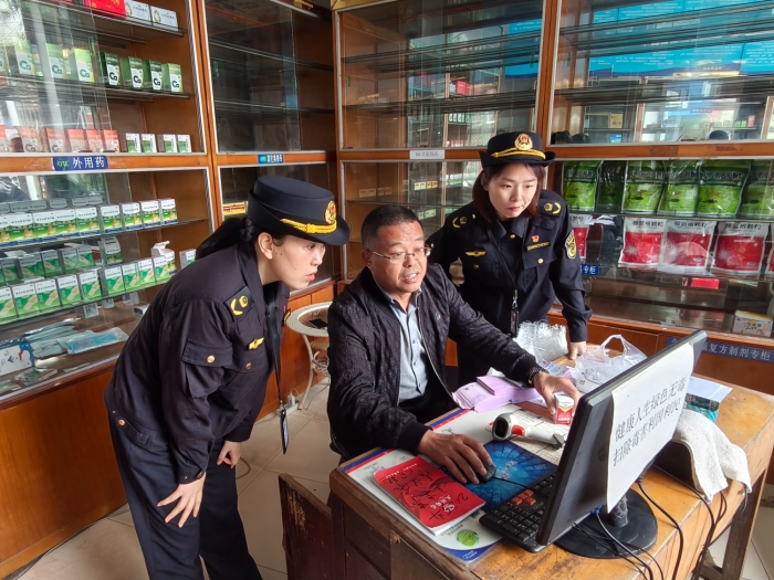 图为4月22日，该局执法人员在一家药店通过核查处方的方式检查执业药师是否存在“挂证”行为。（钱存 文光辉 摄）