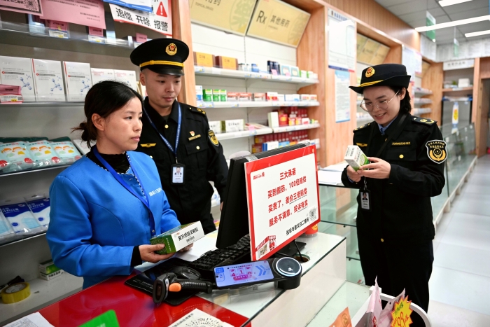 图为10月27日，该局执法人员在一家药店核查处方药销售台账。（通讯员 文光辉 摄）