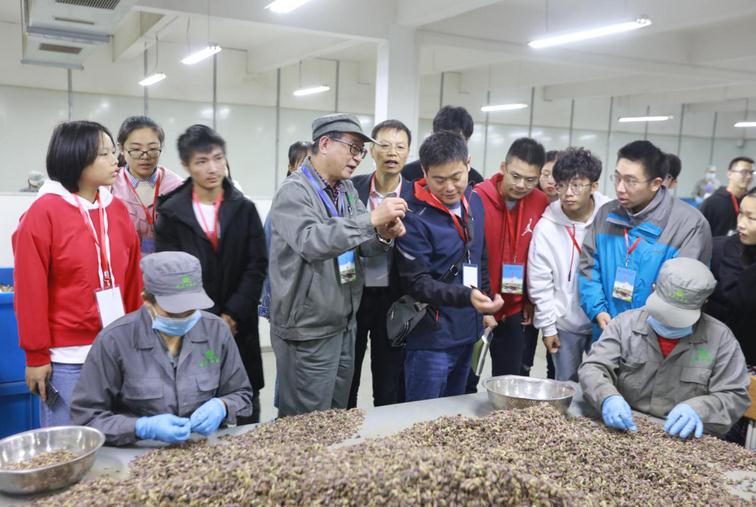 图为明贝堂的工作人员向参观学生介绍药品知识