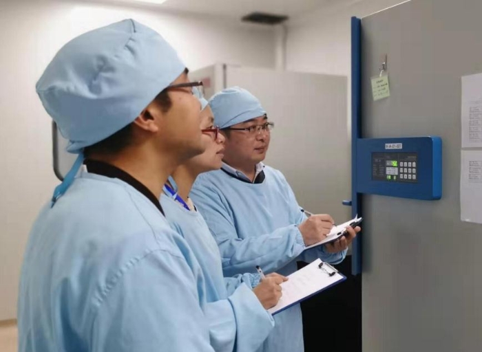 图为派驻检查员在疫苗生产企业检查疫苗原液生产车间毒种库（江苏药监局供图）