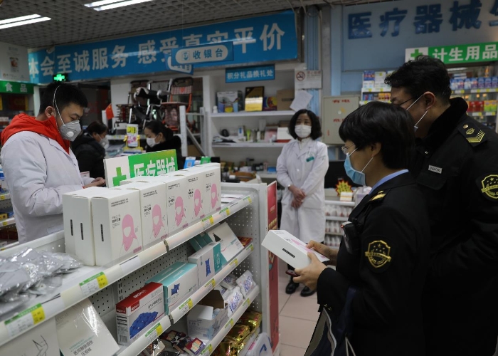 朝阳区局执法人员对团结湖一家药店的防护用品进行检查。