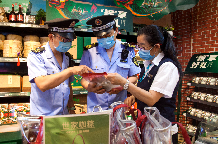 东城区市场监管局执法人员在超市检查粽子保质期。