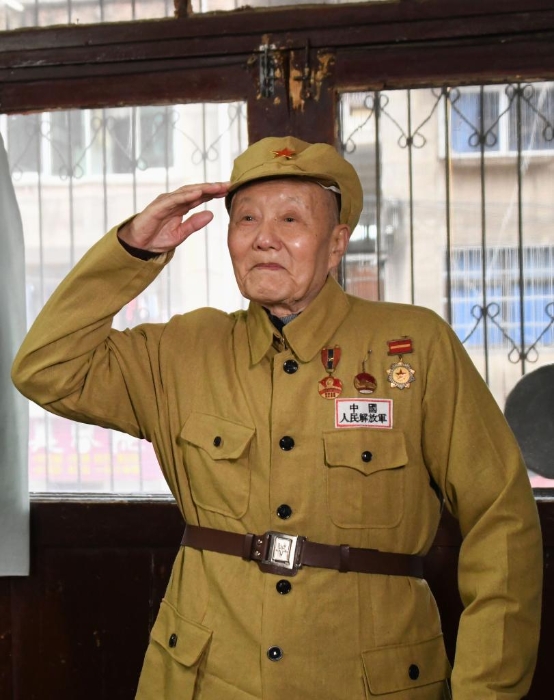 张富清穿着老式军装敬军礼(2019年3月31日摄).新华社记者 程敏 摄