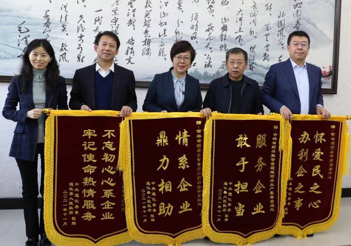 图为通化县委领导给吉林省药监局送来四面锦旗.