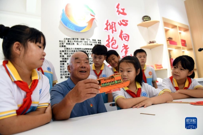 2022年8月4日，在山东省日照市东港区涛雒镇东南营村新时代文明实践站，老党员秦玉山给学生讲“红船故事”。新华社记者 范长国 摄