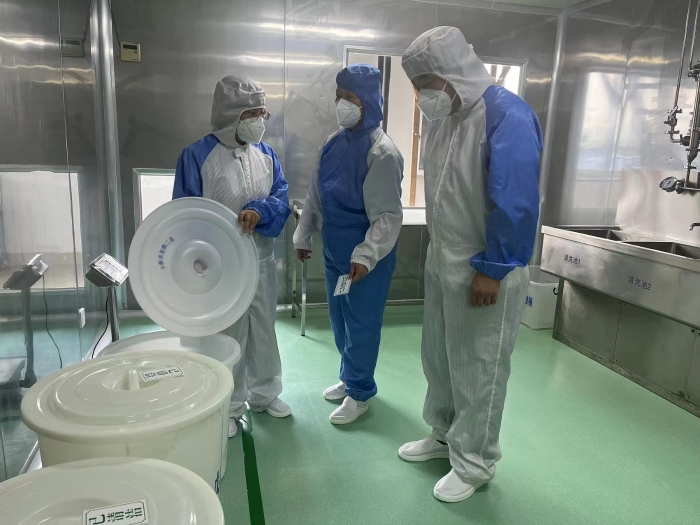 图为监管人员在企业生产车间开展半成品冲裁检查。（高金凤 摄）