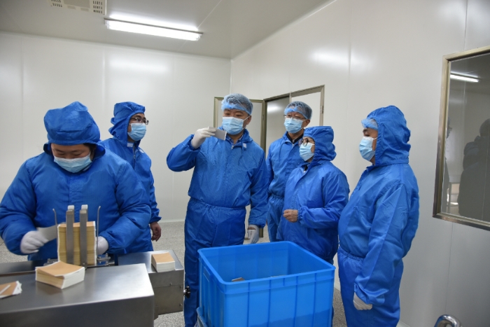 图为甘肃省药监局党组书记、局长吉永锋（右四）带领调研组在白银振亚卫生材料有限公司查看祖师麻关节止痛膏生产情况 。 （卢昌贵 摄）