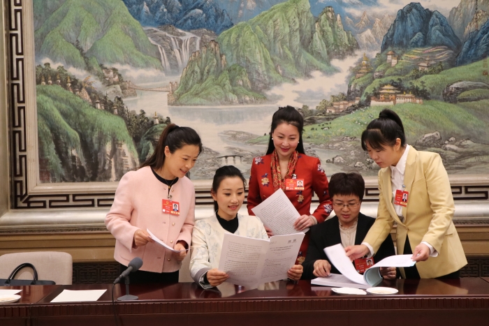 3月7日上午，十四届全国人大三次会议北京市代表团举行代表小组会议，审查计划报告和草案、预算报告和草案。图为上午会议结束后，北京市代表团部分女代表仍在继续讨论预算草案中的化妆品安全监管项目。本报记者蒋红瑜 摄