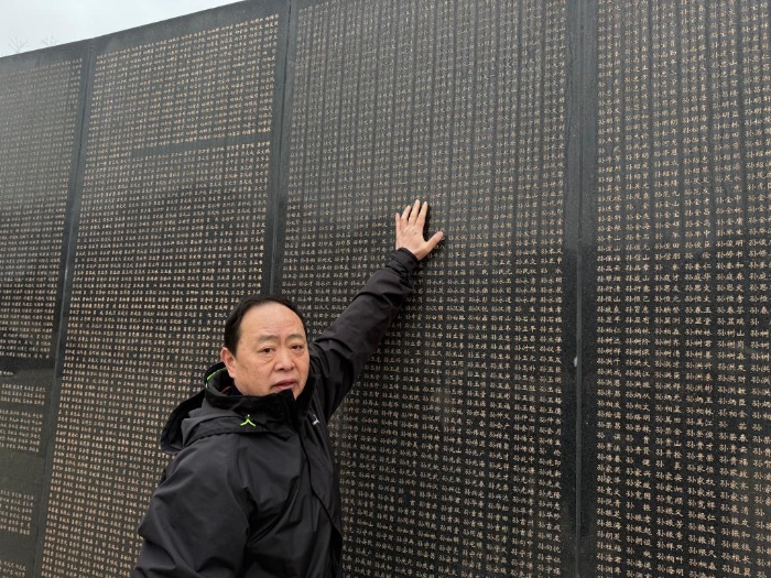 图为孙胜德指着烈士英名墙上“孙世安”烈士的名字。新华社记者洪可润 摄