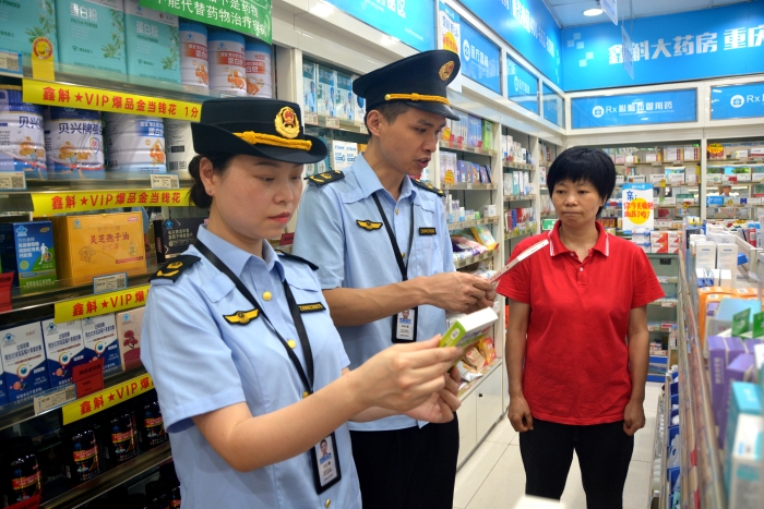 图为6月18日，该局执法人员在一家药店对是否销售回流药进行核查。（通讯员 文光辉摄）