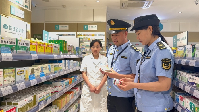 图为该局执法人员在校园附近的一家药店检查药品质量和经营情况。（韩吴琦 摄）