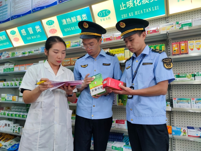 图为该局执法人员在一家零售药店检查药品进货台账。（通讯员 鄢国卿 摄）