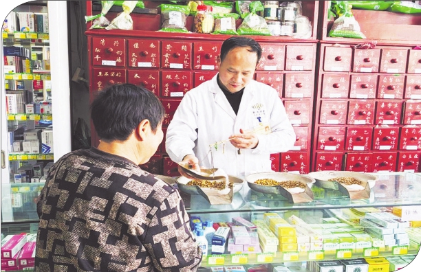 图为朱新兵（右）在为顾客调配方剂。 图片由作者提供