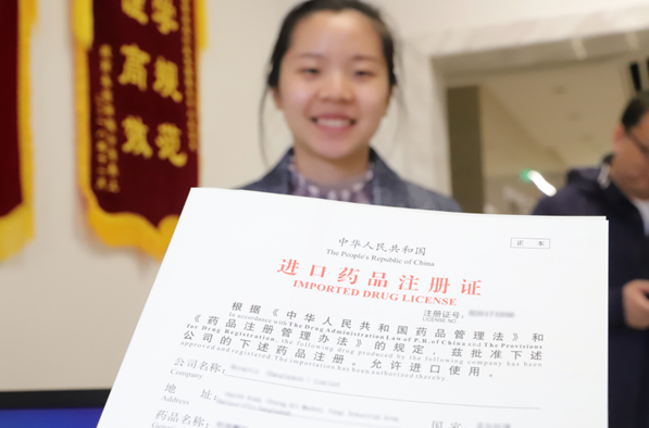 图为上海诺华贸易有限公司办事人员领取进口药品注册证.
